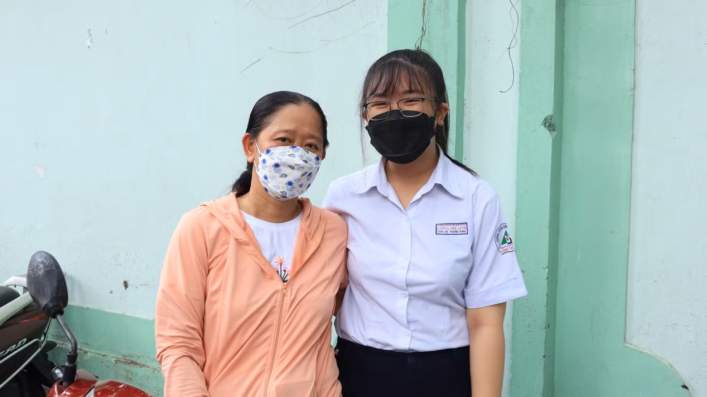 Chị Phương Thảo cùng con gái của mình tại điểm thi trường THCS Võ Trường Toản, TP. HCM.