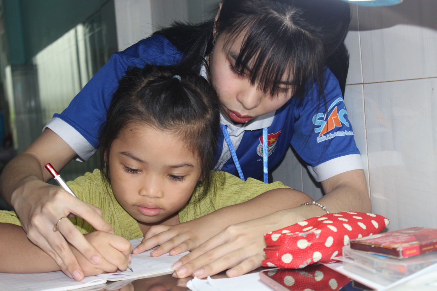 Ngọc Trân đang kèm cho bé Thảo Nhi viết chữ. Ngọc Trân đang kèm cho bé Thảo Nhi viết chữ.