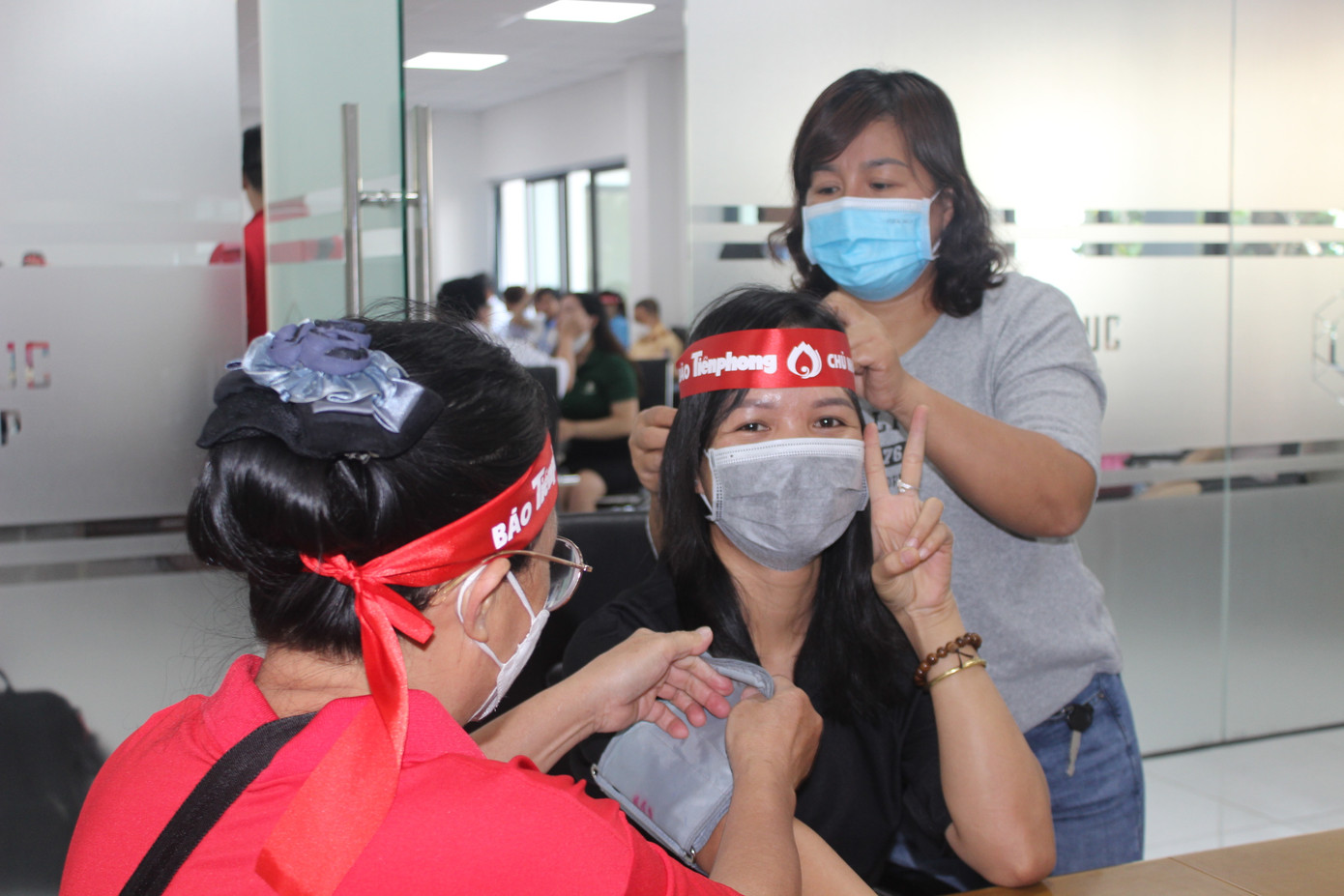 Nhân viên y tế đo huyết áp cho người dân trước khi vào khám sàng lọc.