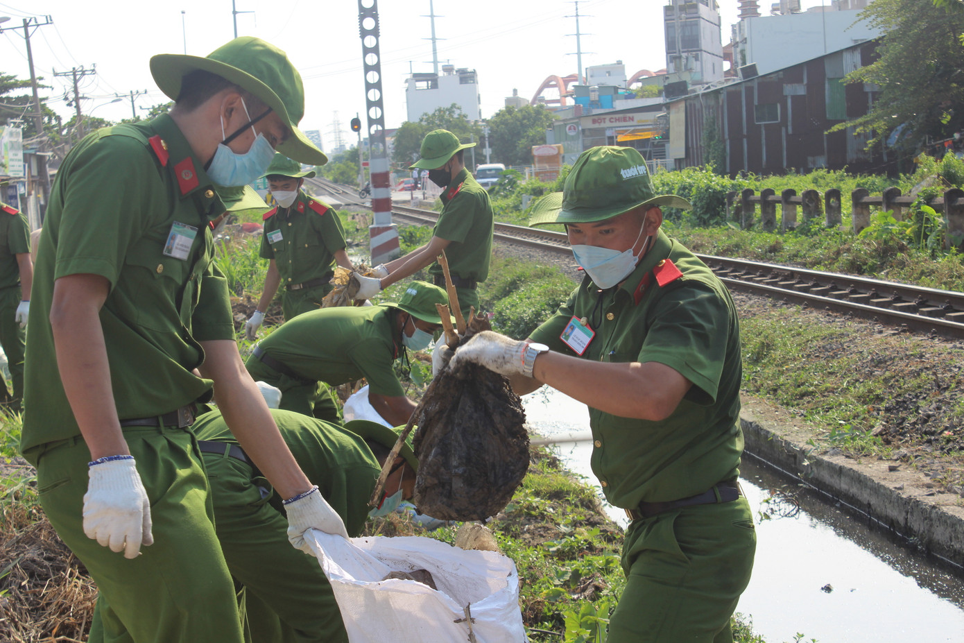 Các chiến sĩ công an cùng tham gia dọn rác trên tuyến đường sắt Bắc - Nam.