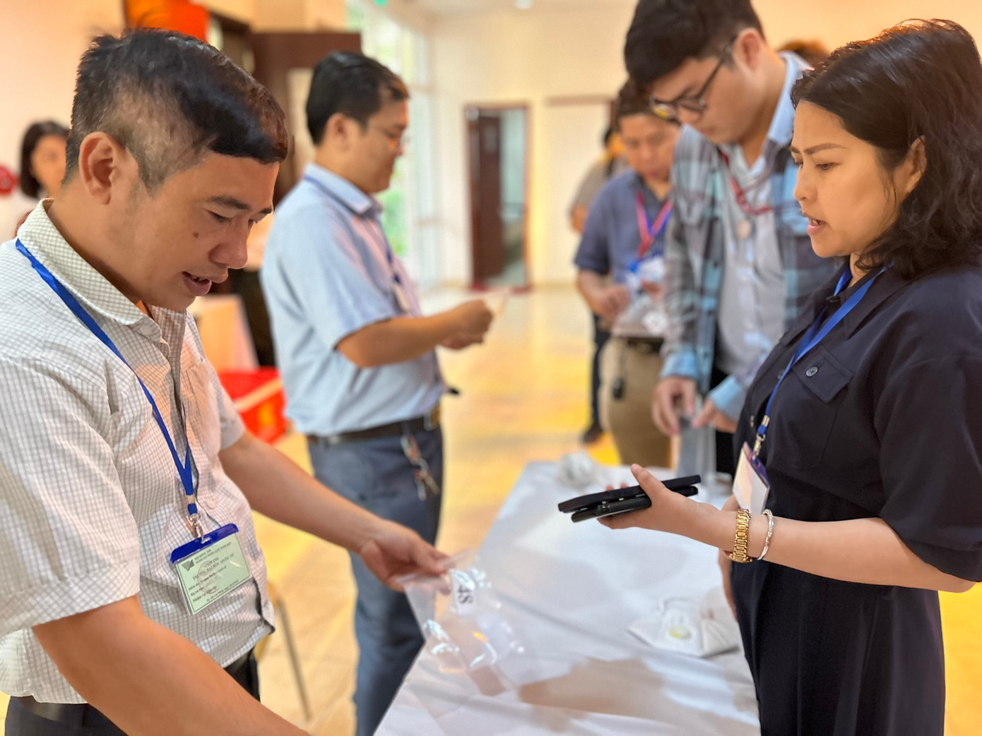 Giám thị làm thủ tục nộp điện thoại cho Hội đồng thi.