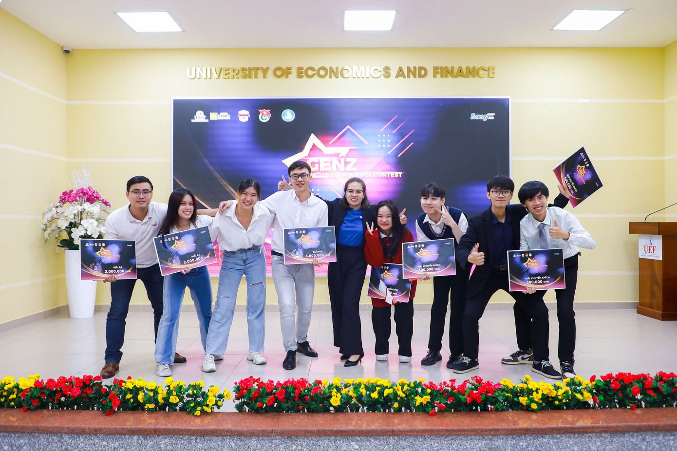 Tấn Đạt (thứ tư, từ trái sang) tại cuộc thi Hùng biện tiếng Anh trường ĐH Kinh tế Tài chính. (Ảnh: NVCC) Tấn Đạt (thứ tư, từ trái sang) tại cuộc thi Hùng biện tiếng Anh trường ĐH Kinh tế Tài chính. (Ảnh: NVCC)