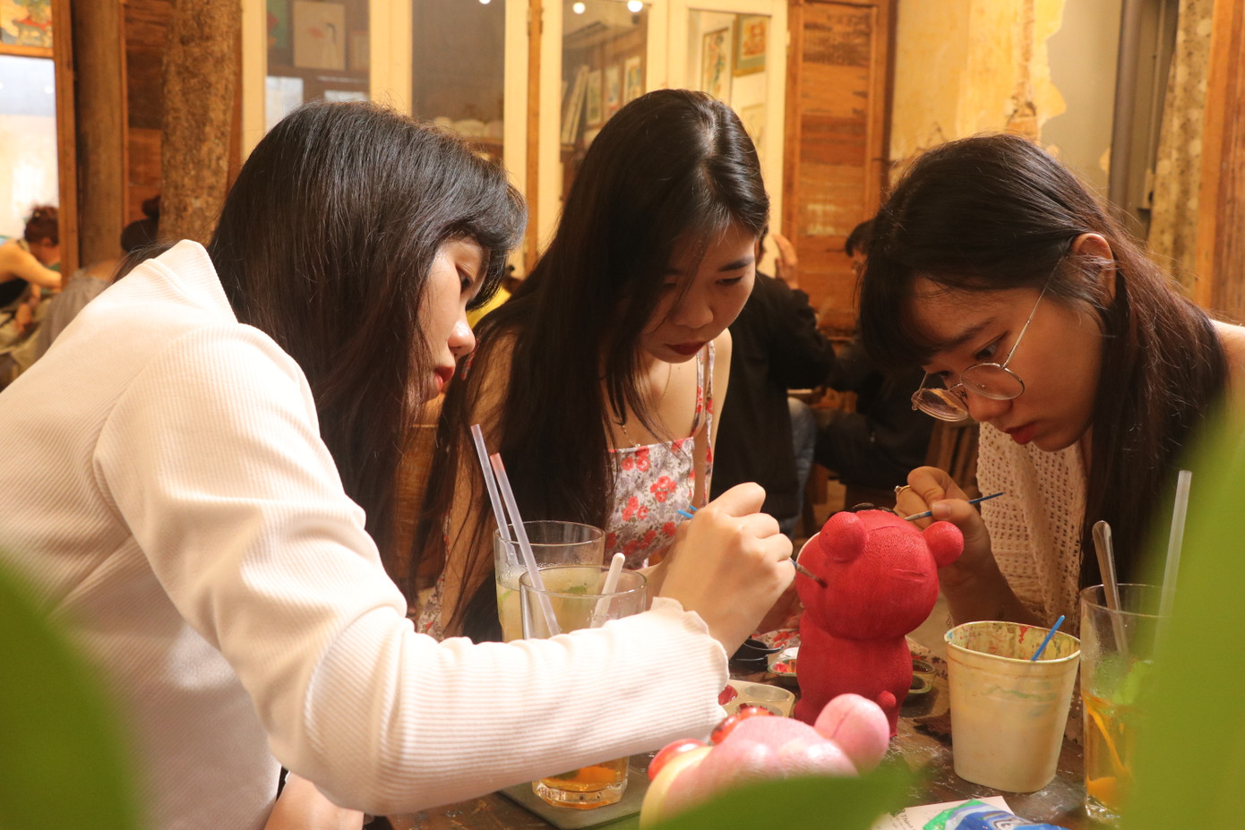 Phương Trúc (giữa) cùng hai người bạn của mình vừa trò chuyện, vừa hoàn thành những bức tượng xinh xắn. (Ảnh: Lan Huỳnh)