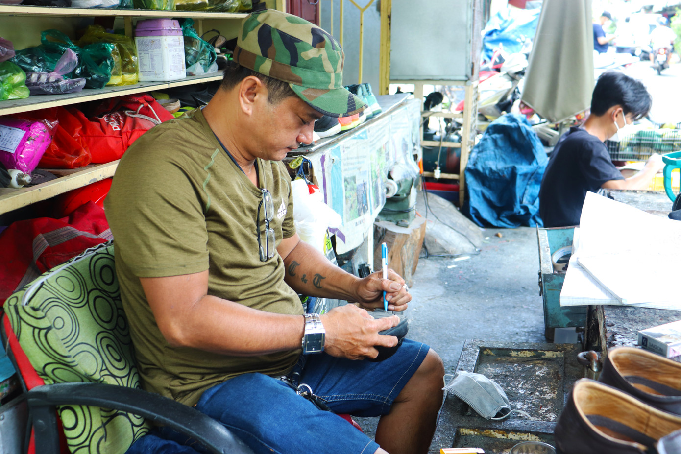 Anh Tuấn đã gắn bó với tiệm sửa giày ngoài trời của mình gần 30 năm. (Ảnh: Phương An)