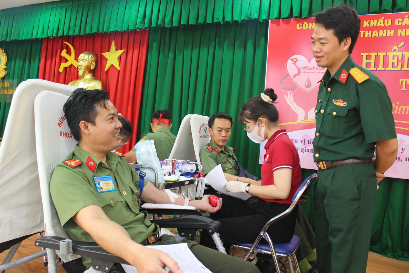 Trung tá – bác sĩ Vũ Sơn Giang - Phó Chủ nhiệm chính trị Bệnh viện Quân y 175 (bên phải) hỏi thăm chiến sĩ hiến máu.