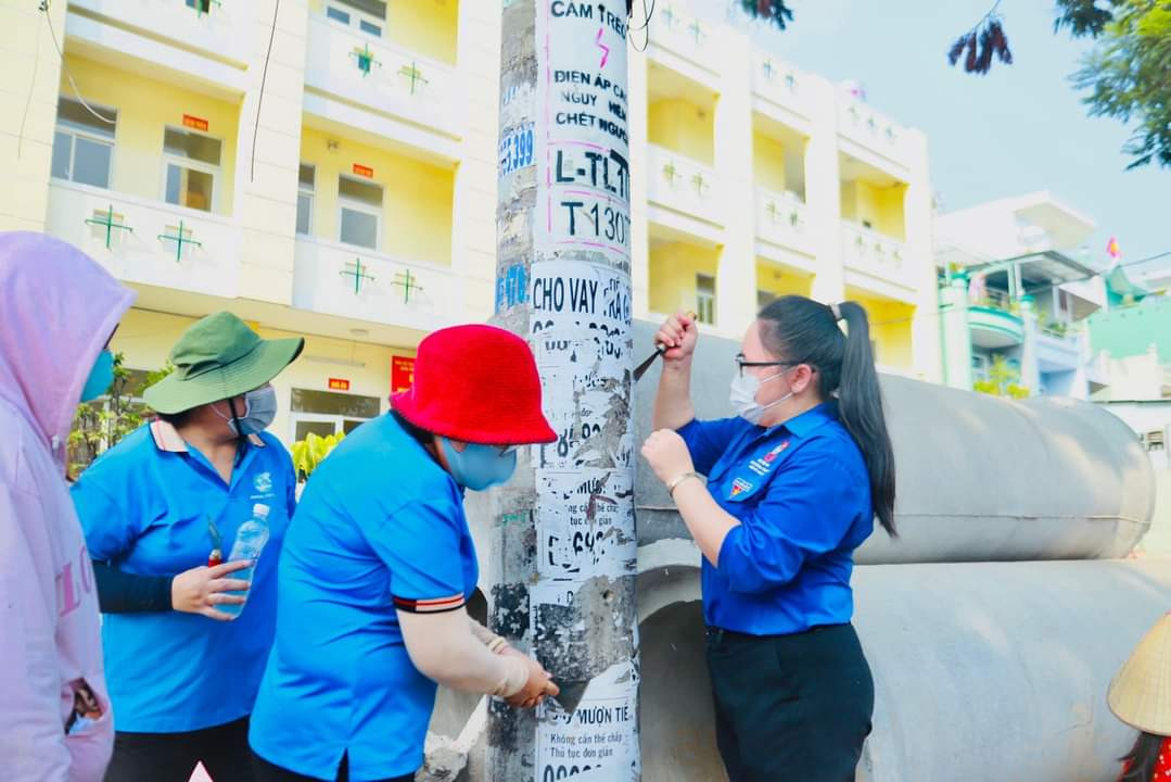 Đoàn viên, thanh niên cùng người dân tham gia hoạt động bóc, xóa các sản phẩm quảng cáo sai quy định. (Ảnh: TLTĐ)