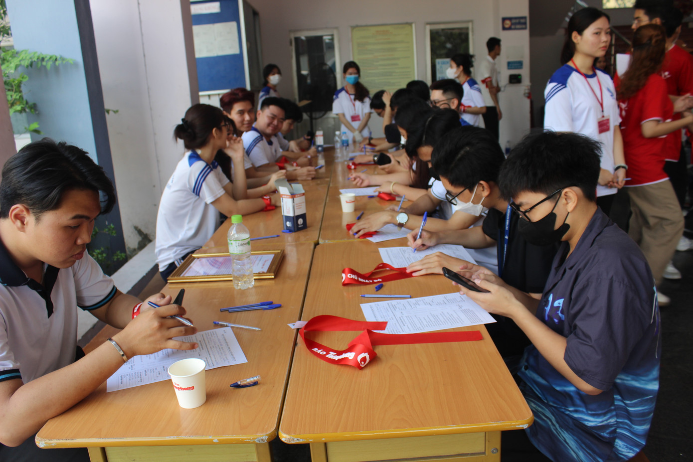 Các bạn sinh viên điền đơn đăng ký hiến máu trước khi đo huyết áp và khám sàng lọc.