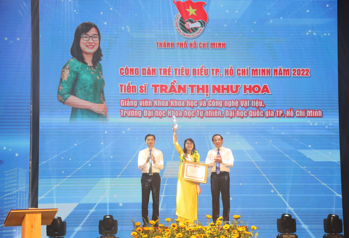 Ông Nguyễn Văn Nên, Ủy viên Bộ Chính trị, Bí thư Thành ủy TPHCM (bên phải) và anh Nguyễn Minh Triết, Bí thư Trung ương Đoàn, Chủ tịch Trung ương Hội Sinh viên Việt Nam (bên trái) trao hoa, bằng khen tặng Tiến sĩ Trần thị Hoa, Giảng viên khoa Khoa học và Công nghệ Vật liệu, Trường ĐH KHTN (ĐHQG TPHCM).