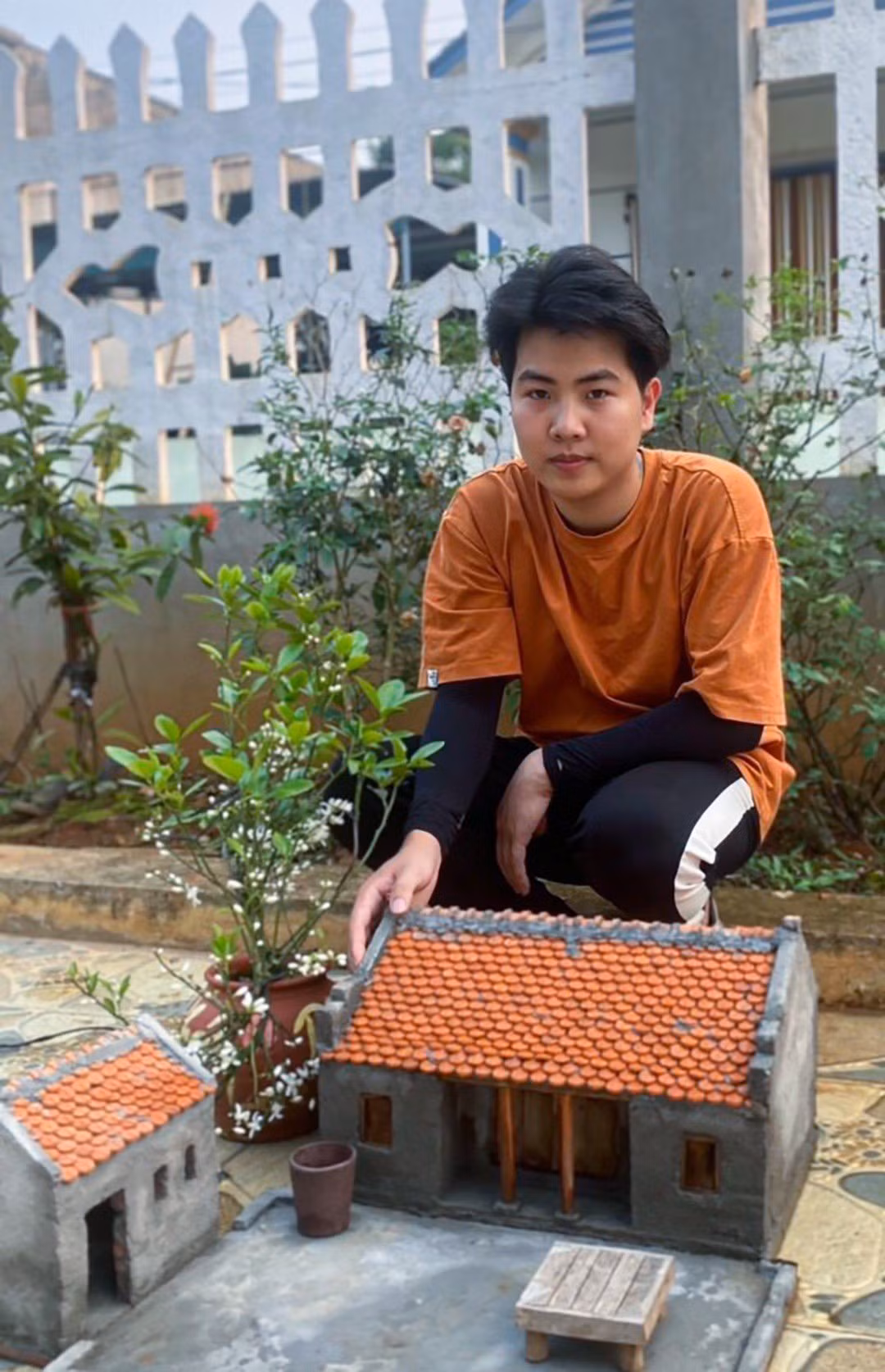 Duy Khánh bên sản phẩm ngôi nhà thu nhỏ mà mình tạo ra.