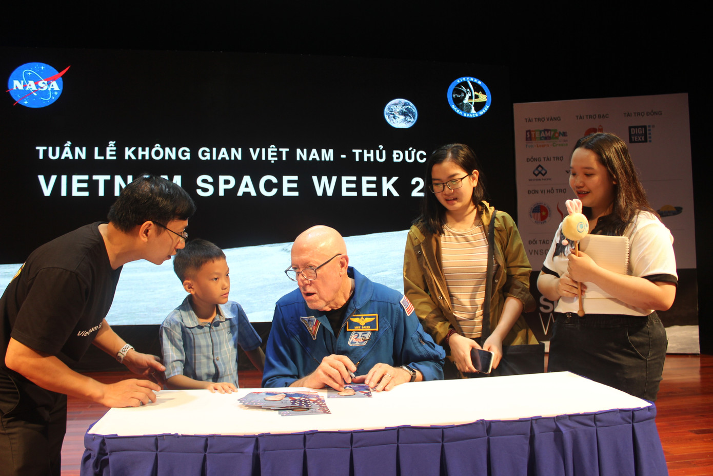 20 bạn trẻ may mắn được ông Michael A. Baker – cựu phi hành gia NASA ký tặng tại chương trình.