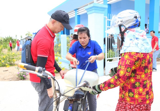 Người dân đi lấy nước sạch từ hệ thống máy lọc về dùng. (Ảnh: Ngô Tùng)