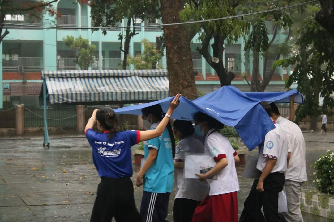 Sinh viên tình nguyện Tiếp sức mùa thi che mưa cho thí sinh kết thúc môn thi chiều ngày 28/6. Ảnh: Hội SV TP. HCM Sinh viên tình nguyện Tiếp sức mùa thi che mưa cho thí sinh kết thúc môn thi chiều ngày 28/6. Ảnh: Hội SV TP. HCM