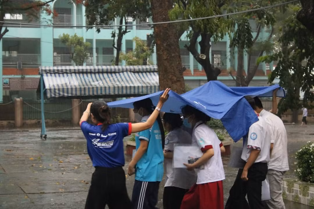 Sinh viên tình nguyện Tiếp sức mùa thi che mưa cho thí sinh kết thúc môn thi chiều ngày 28/6. Ảnh: Hội SV TP. HCM Sinh viên tình nguyện Tiếp sức mùa thi che mưa cho thí sinh kết thúc môn thi chiều ngày 28/6. Ảnh: Hội SV TP. HCM