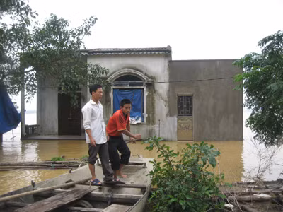Anh Thuật và anh Kha (áo đỏ) trên chiếc xuồng đã cứu cha con anh Thịnh