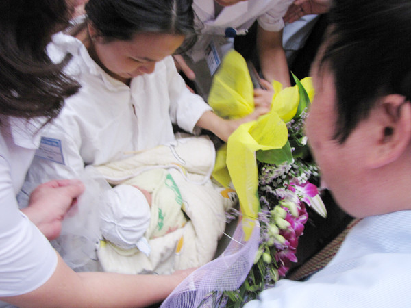 Khoảnh khắc chị Thơm nhận lại con từ đại diện bệnh viện và cơ quan điều tra. Ảnh: Lãng Phong