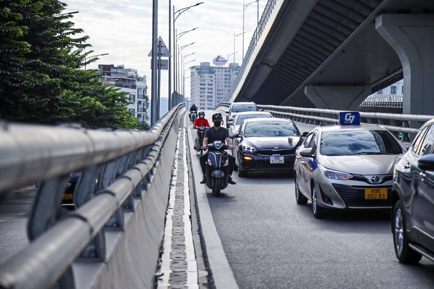 Xe máy xếp thành hàng dài đi vào đường của ô tô.