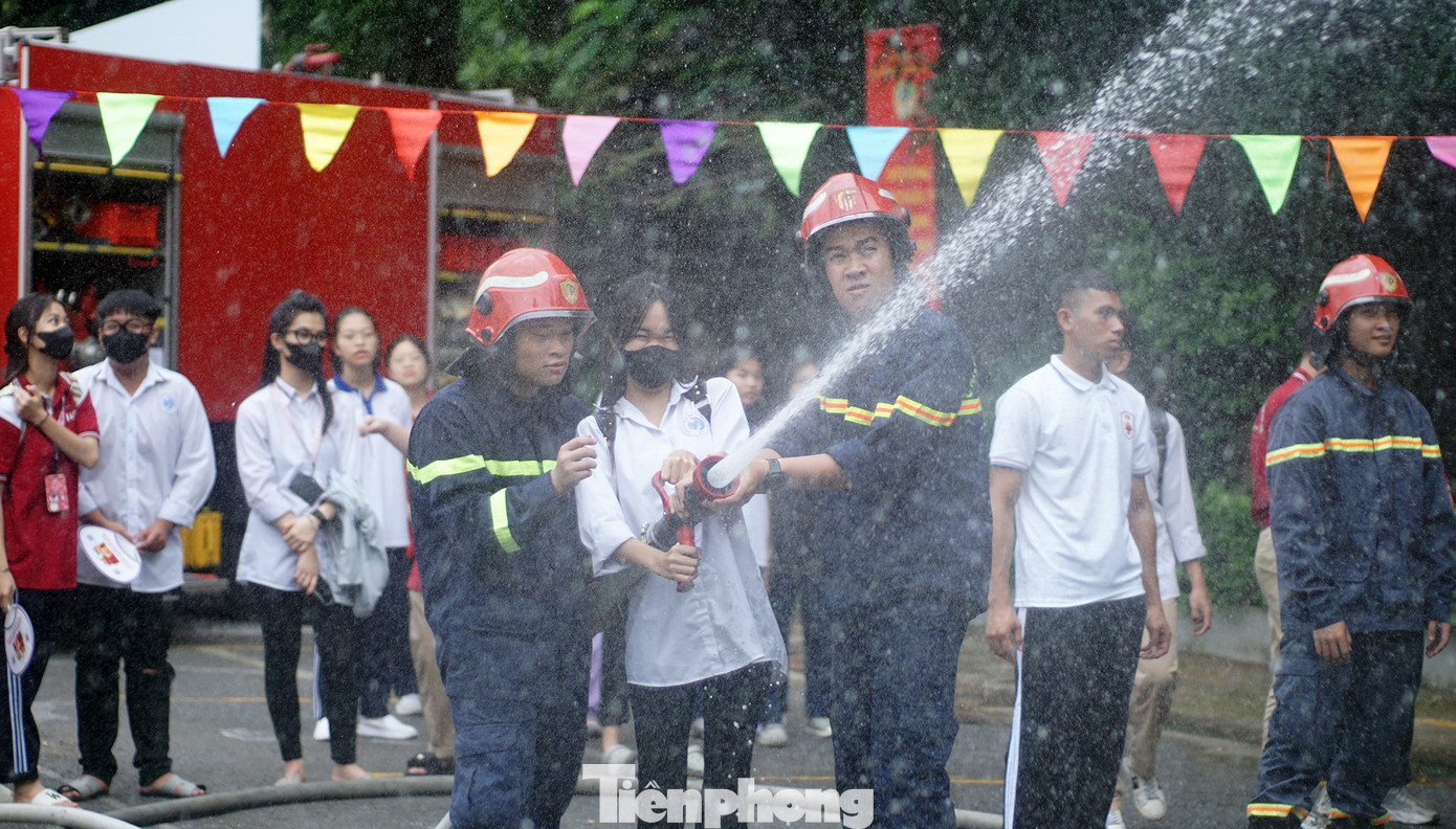 Cán bộ, chiến sĩ PCCC&amp;CNCH hướng dẫn học sinh, sinh viên cách phun vòi nước chữa cháy hiệu quả.