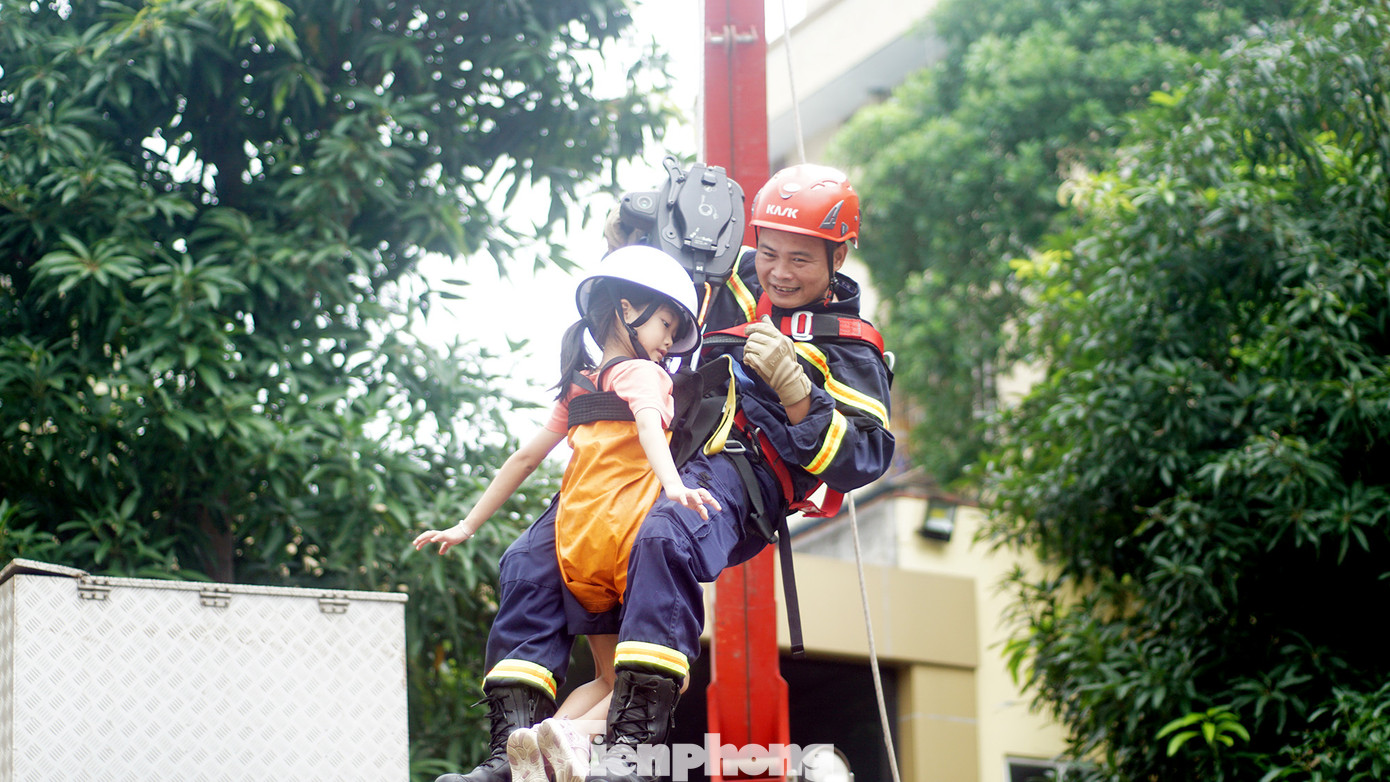 Các em nhỏ được cán bộ, chiến sĩ PCCC&amp;CNCH hướng dẫn thoát nạn bằng dây.