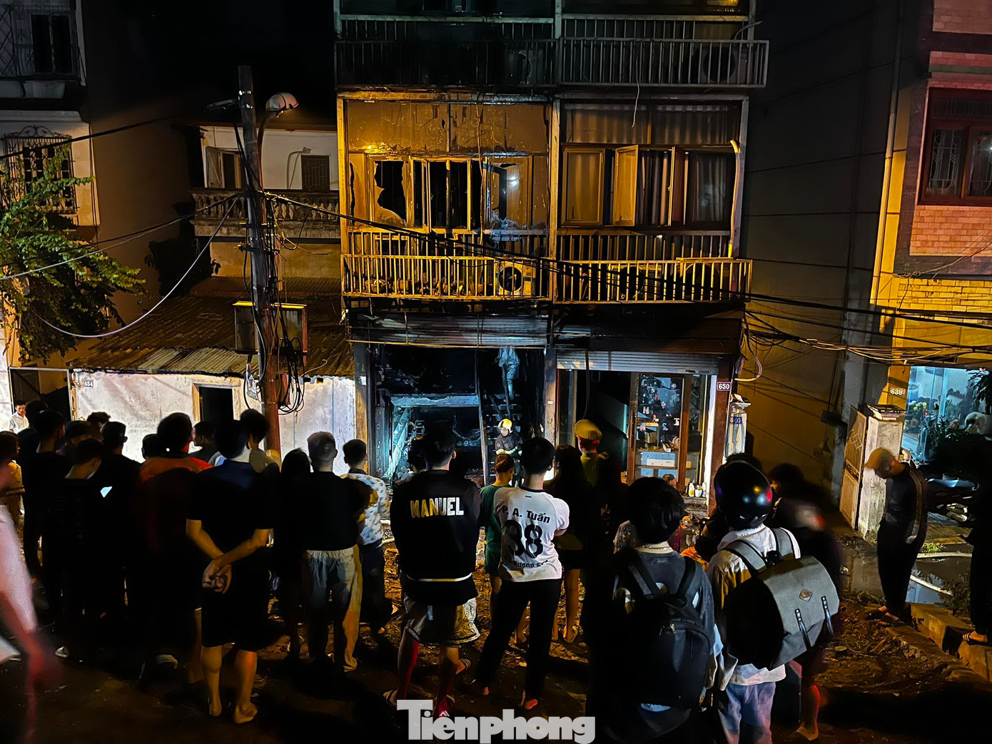 Nhiều người dân tập trung bên ngoài ngôi nhà theo dõi sự việc.