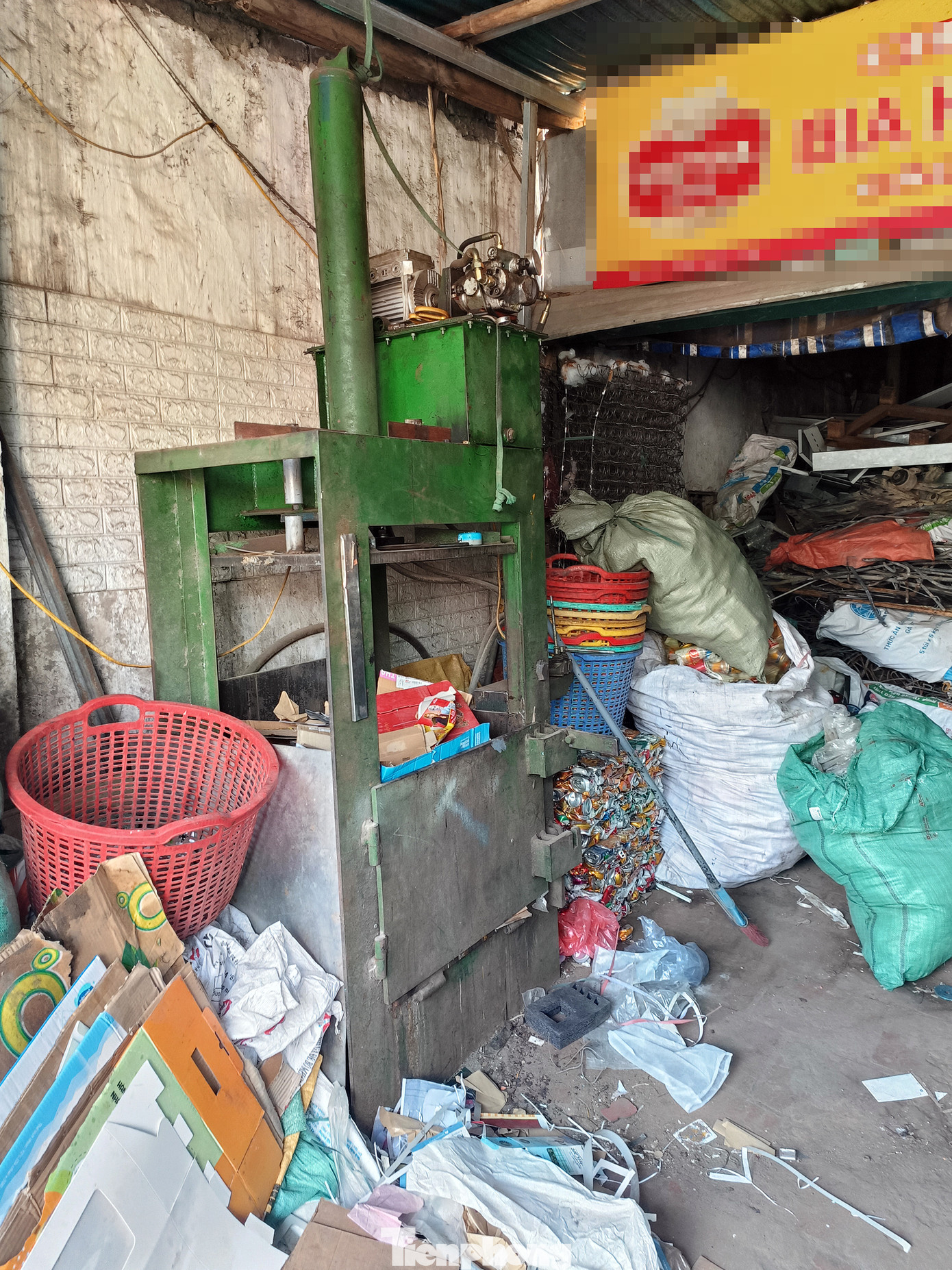 Theo một người phụ nữ kinh doanh mặt hàng này, họ có nghe nói đến vụ cháy hôm qua làm 4 người thương vong. Đồng thời cho biết, gia đình cũng đã trang bị bình chữa cháy đề phòng trường hợp xảy ra hỏa hoạn. Trong ảnh là máy ép chuyên dụng dùng để ép các loại vỏ lon kim loại thành các khối có kích thước 50-60cm.