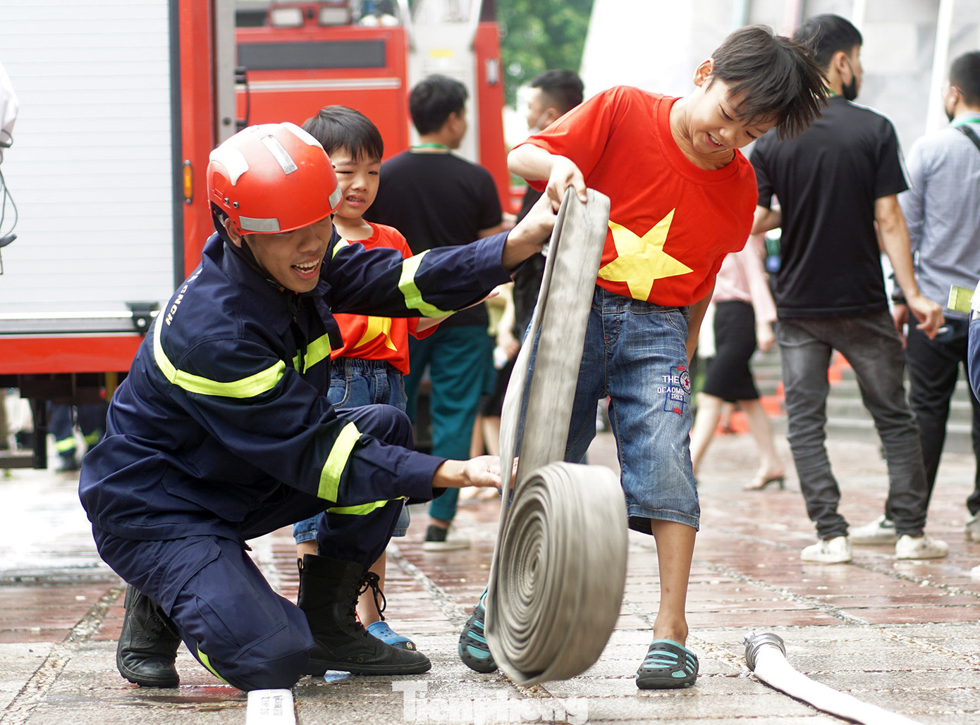 Các em học sinh được thực hành trải vòi chữa cháy. Ảnh: Thanh Hà