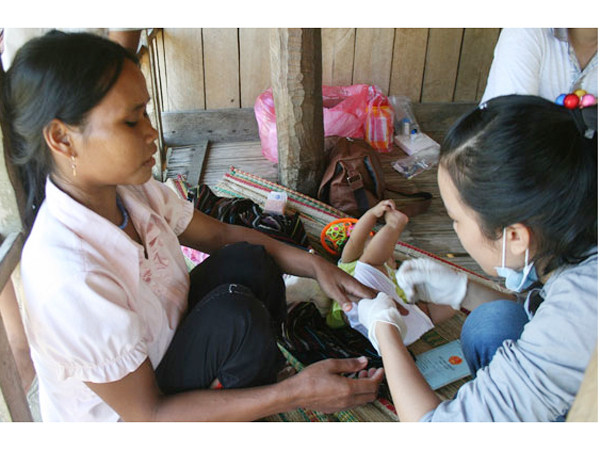 Lấy mẫu bệnh phẩm tại nhà một người dân ở làng Rêu - Ảnh: Đ.Cường