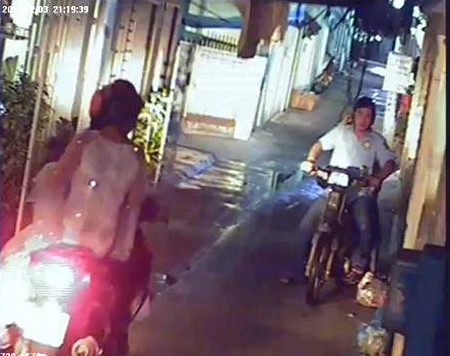 Hai tên trộm kiên nhẫn đứng chờ trước cửa nhà. Ảnh chụp từ clip.