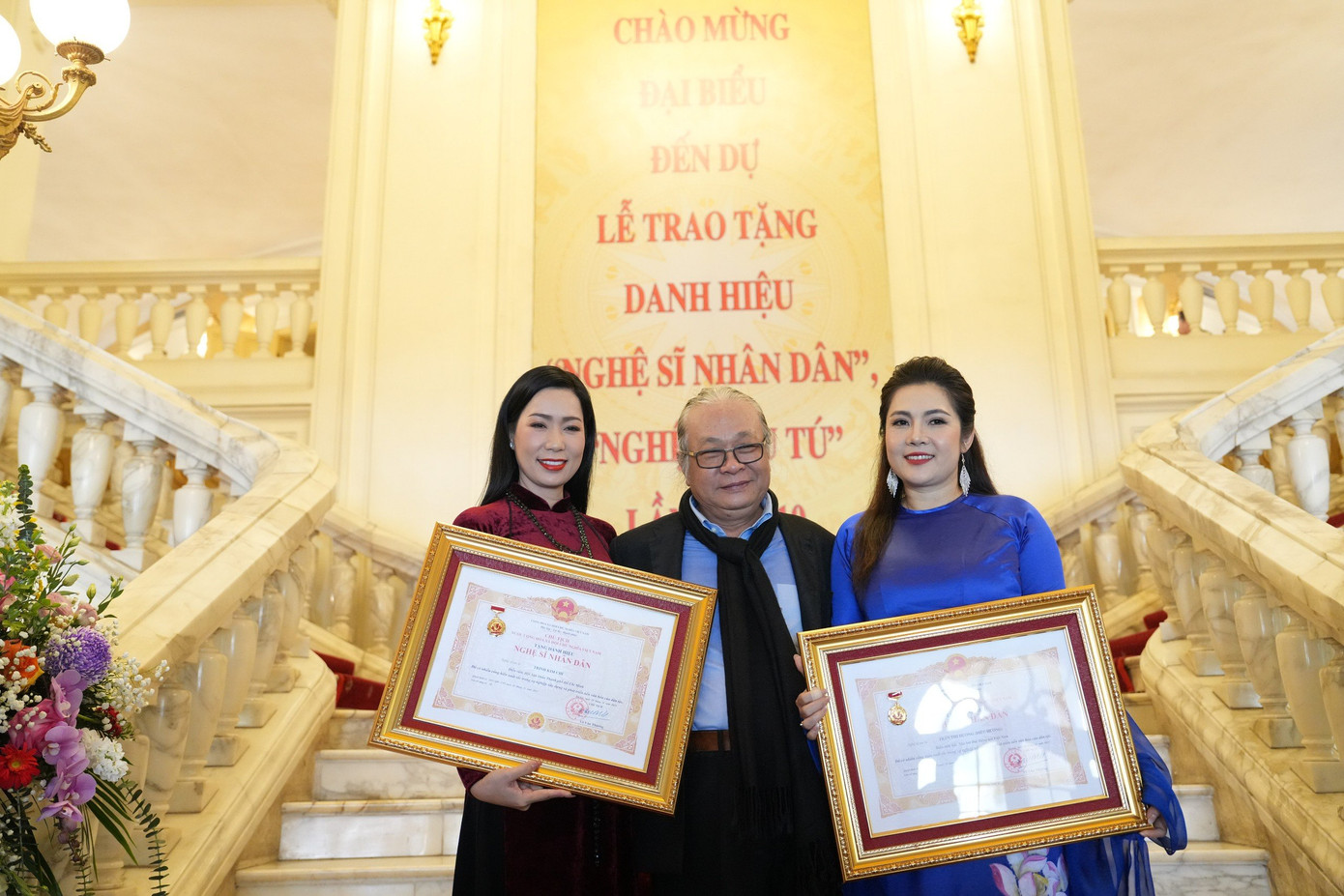 NSND, á hậu Trịnh Kim Chi hân hoan chụp ảnh lưu niệm. Trịnh Kim Chi là Á hậu Việt Nam đầu tiên được phong danh hiệu NSND. Chị gặt hái được nhiều thành công trên sân khấu kịch với các vai diễn trong nhiều vở diễn như Loài hoa bất tử, Hạ trắng, Vụ án trộm trứng gà, Hoa hậu trăm năm...NSND Trịnh Kim Chi đoạt nhiều giải thưởng như Huy chương vàng Liên hoan Kịch nói chuyên nghiệp toàn quốc vào các năm 1995, 2012, 2018, 2020, Bằng khen của Hội Nghệ sĩ Sân khấu Việt Nam năm 2021...