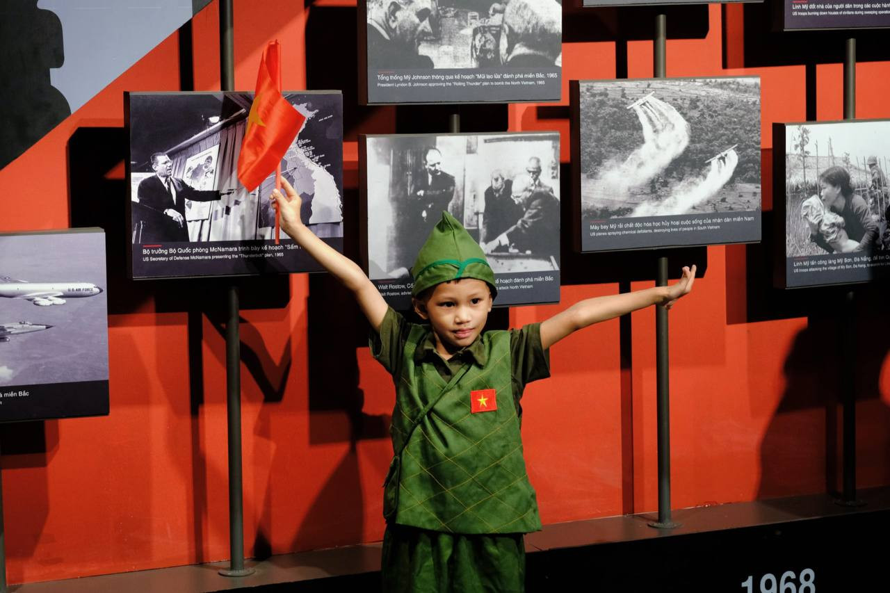 Cờ đỏ sao vàng được một du khách nhí vẫy cao trong không gian trưng bày.