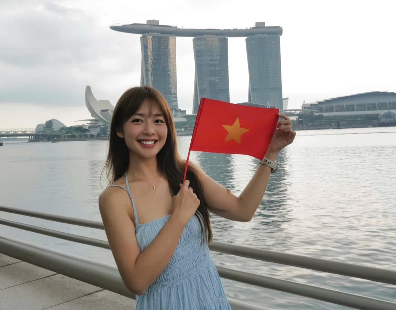 Diễn viên Khả Ngân check-in cùng cờ đỏ sao vàng tại điểm du lịch nổi tiếng của Singapore. Dù không có mặt ở Việt Nam dịp này, nữ diễn viên vẫn thể hiện lòng yêu nước, tinh thần dân tộc.