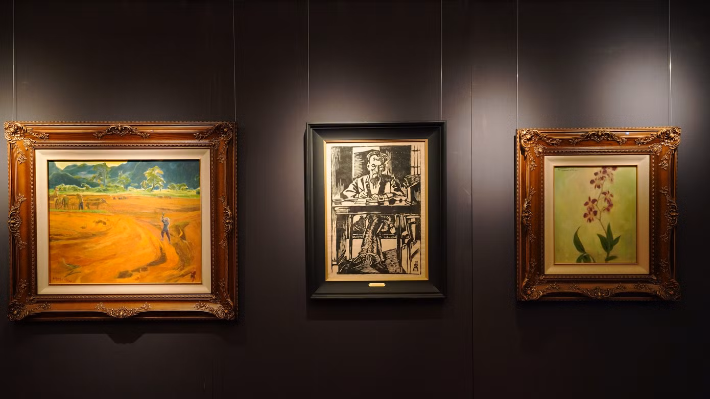 Tranh khắc gỗ Bác Hồ ở Bắc Bộ Phủ (giữa) và một số tác phẩm được trưng bày tại phiên đấu giá chiều 12/10.