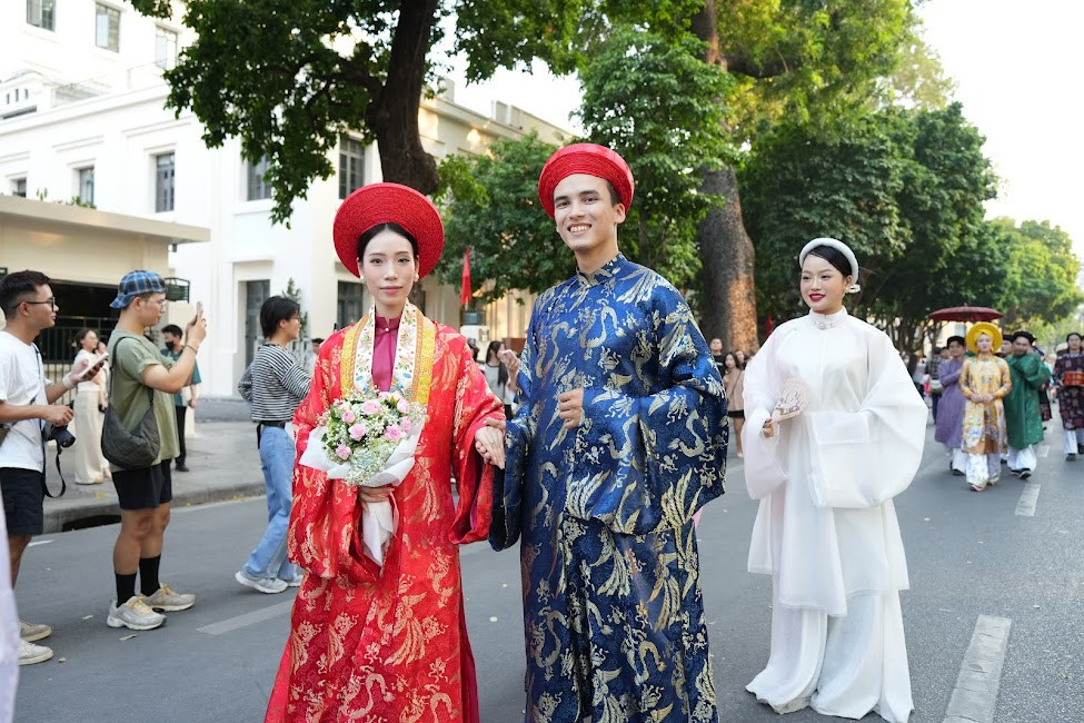 Du khách xếp hàng dọc các tuyến phố lớn để ghi lại khoảnh khắc đoàn rước đi qua.