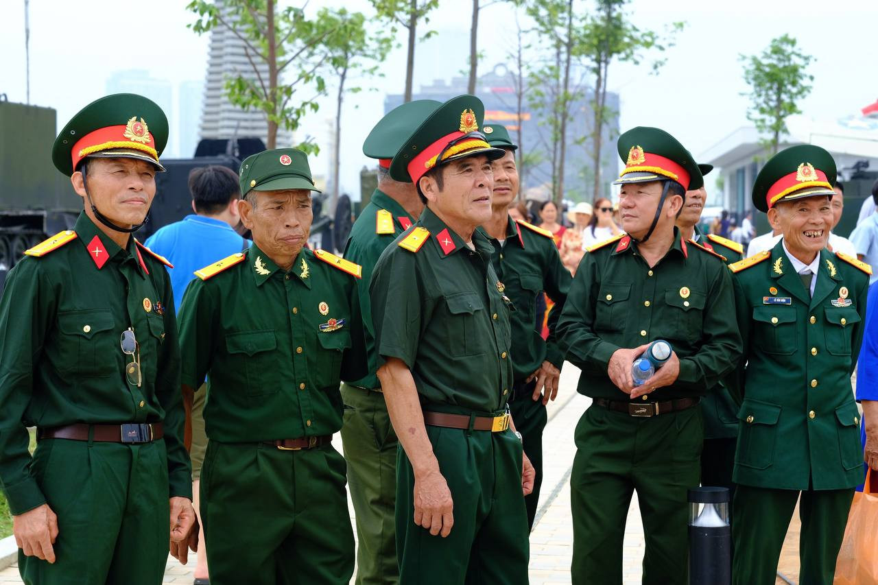 Một nhóm cựu chiến binh chiêm ngưỡng hiện vật ở không gian trưng bày ngoài trời. Ông Nguyễn Đức Nghì (giữa) - người lính lái xe Trường Sơn năm xưa - xúc động và tự hào khi nhớ lại một thời hoa lửa.