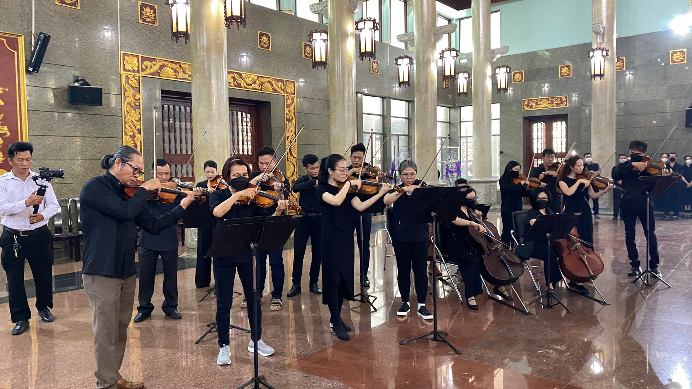 Bản nhạc Trở về đất mẹ của nhạc sĩ Nguyễn Văn Thương vang lên trong lễ tang. Ảnh: Đào Mác.