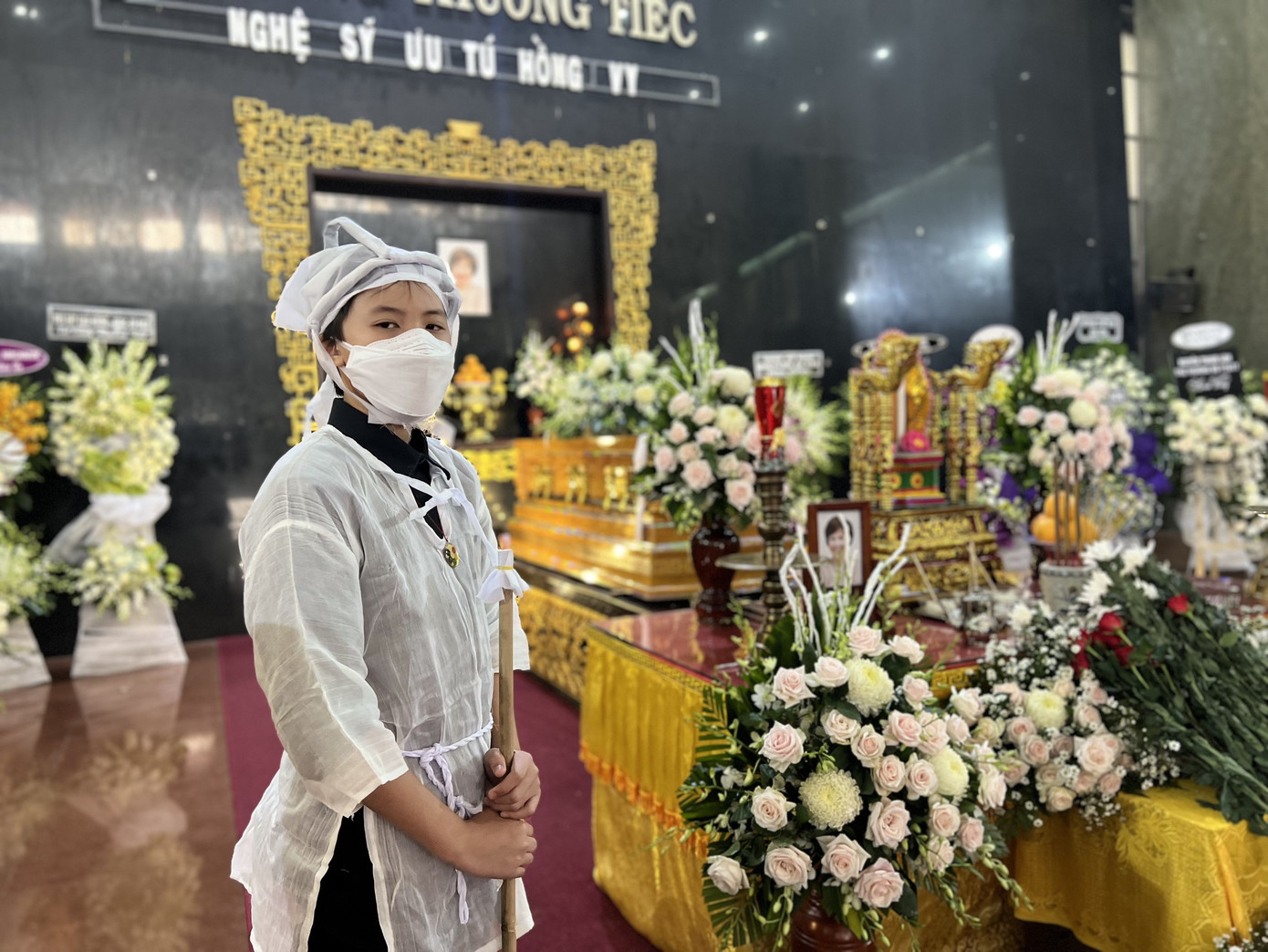 Con trai Hồng Vy túc trực bên linh cữu. Ảnh: Đào Mác.