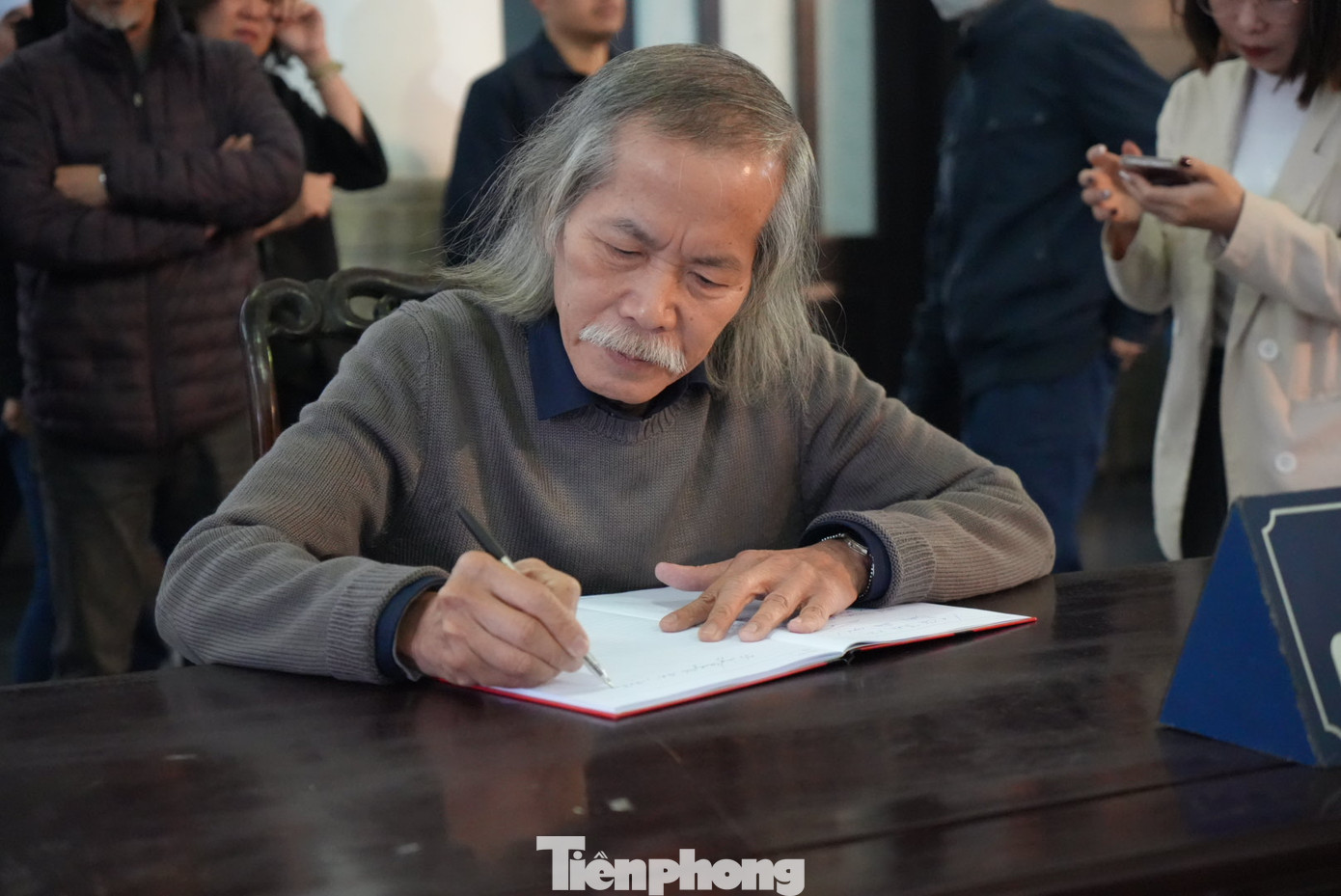 Chủ tịch Hội Mỹ thuật Việt Nam ghi sổ tang, tưởng nhớ dịch giả Dương Tường. Ảnh: TRỌNG QUÂN.
