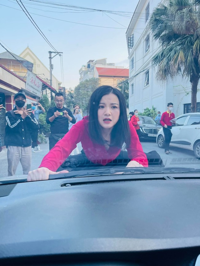 Diễn viên Thanh Hòa nhoài người nằm lên nắp capo để thực hiện cảnh quay. Ảnh: CMH.