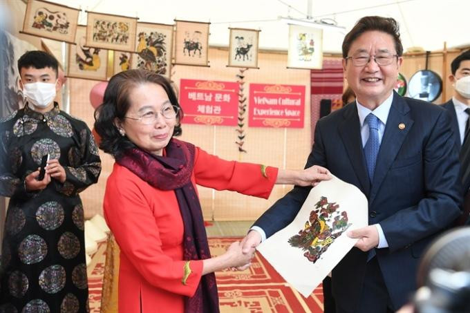 Bộ trưởng Park Bo Gyun được nghệ nhân Nguyễn Thị Oanh tặng tranh Đông Hồ. Ảnh: THẾ CÔNG.