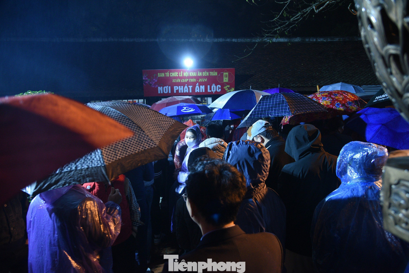 Nhiều người đội mưa thức xuyên đêm chờ tới phần phát ấn.