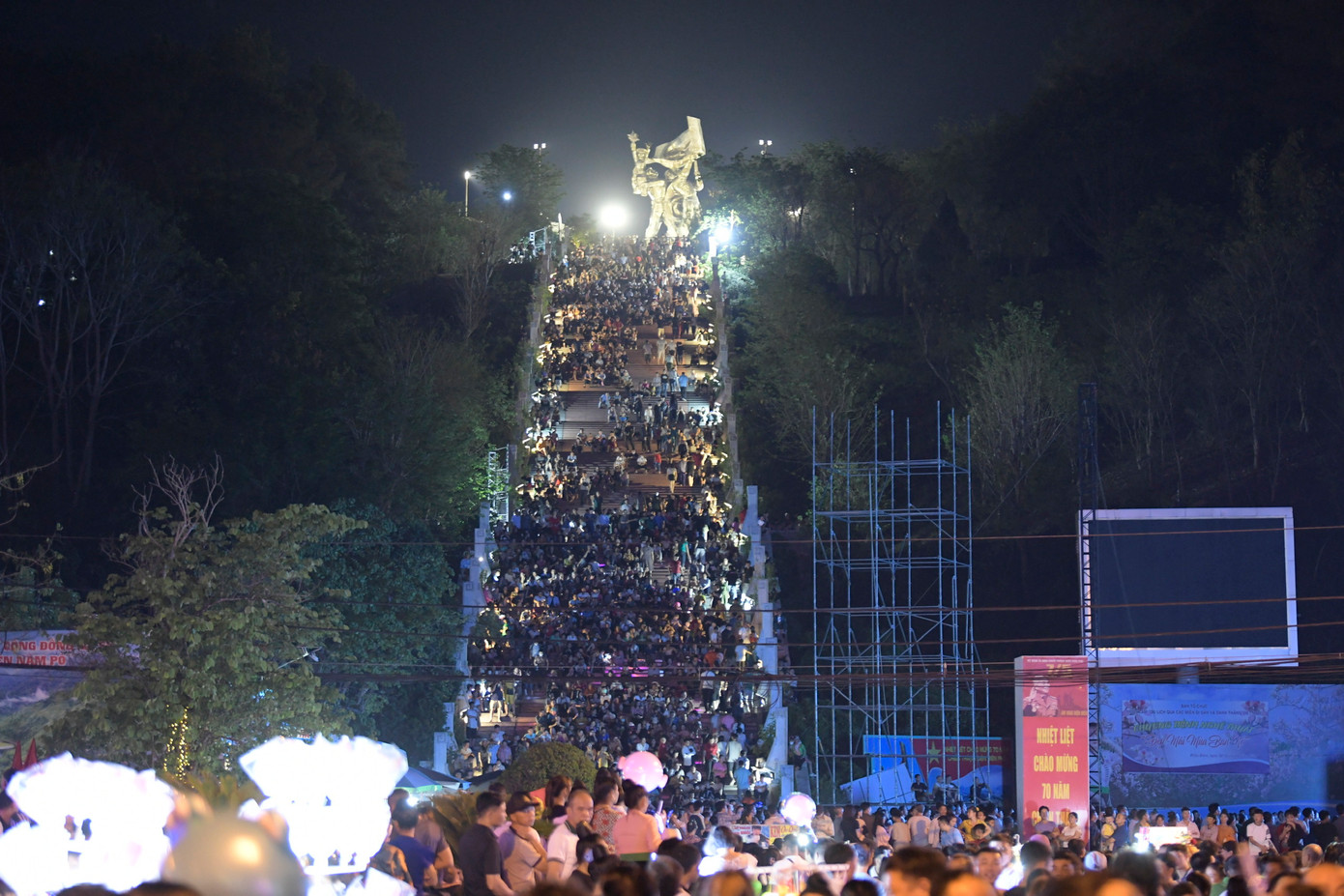 Người dân ngồi kín dọc bậc thang lên tượng Đài chiến thắng Điện Biên Phủ để chờ xem pháo hoa.