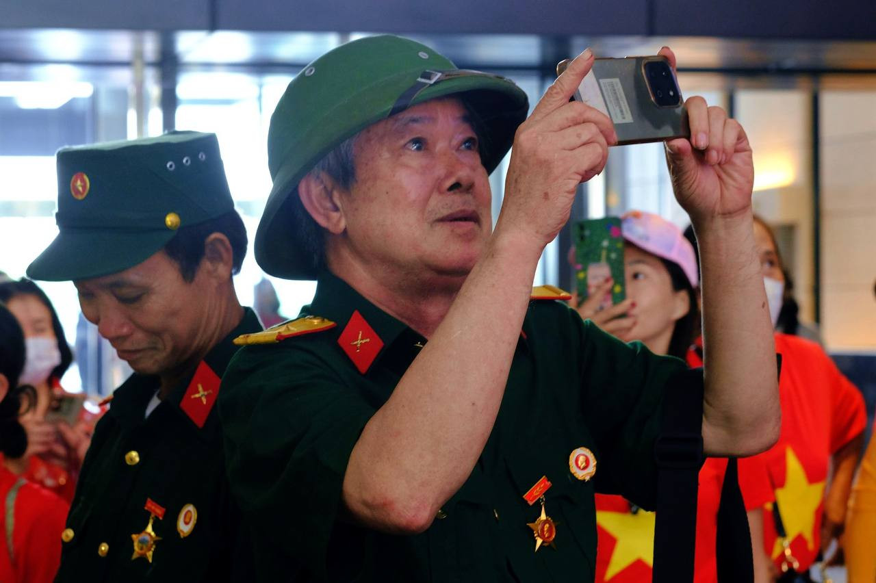 Một cựu chiến binh chụp lại hình ảnh chiếc máy bay được trưng bày tại sảnh chính.