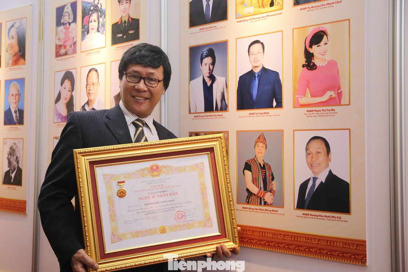 NSND Đồng Minh (Nhà hát Ca, Múa, Nhạc Việt Nam) bên triển lãm chân dung các nghệ sĩ nhận danh hiệu.