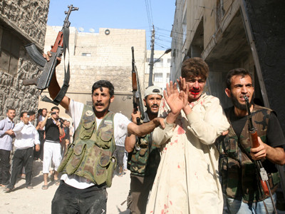 Quân nổi dậy Syria (cầm súng) bắt một cảnh sát bị thương ở thành phố Aleppo. Nguồn: Tootlafrance