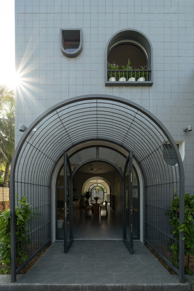 Ban công ở phía trước đã được lược bỏ, để ưu tiên cho lối vào hình vòm có mái che nhằm tối đa hóa không gian. Các lối vào này được tô điểm bằng những cây leo đan xen dọc theo các mái vòm, tạo thêm nét thiên nhiên cho mặt tiền.