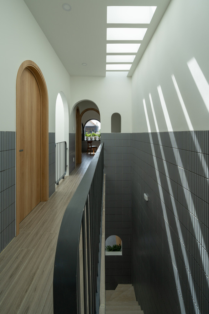 Cầu thang, phòng tắm và kho được bố trí chiến lược sang một bên, tối đa hóa luồng không khí mở từ trước ra sau của các không gian sinh hoạt chính.