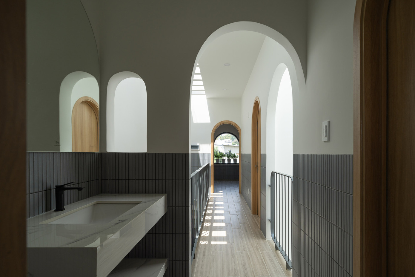 Tầng trên có ba phòng ngủ và một phòng tắm chung. Một giếng trời ở giữa, kết hợp với cây xanh, nối liền hai tầng.