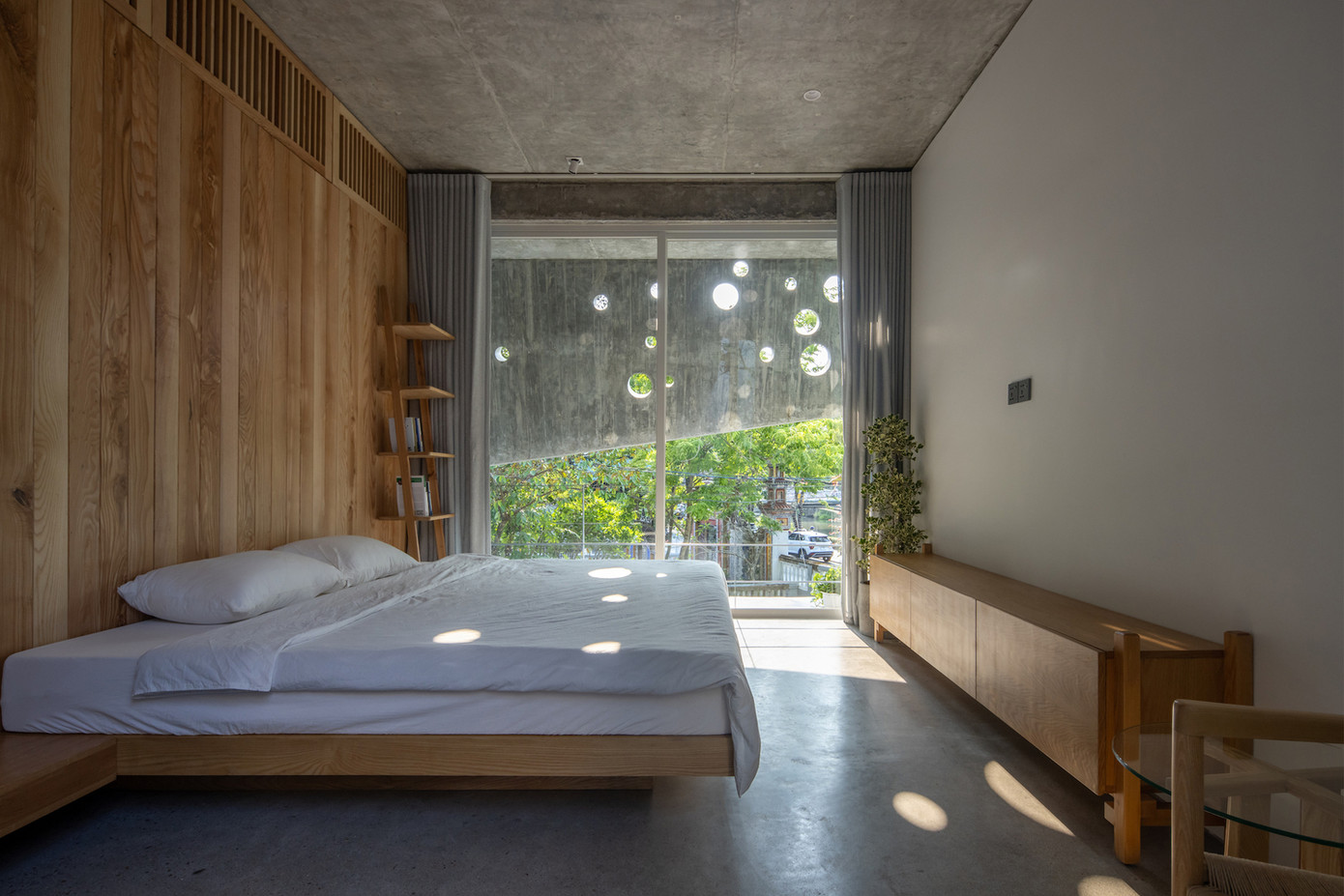 Cửa kính trượt lớn duy trì tầm nhìn thông thoáng, trong khi gỗ tạo ra bầu không khí ấm cúng bên trong, hài hòa với các vật liệu như bê tông và thép hoặc kính.