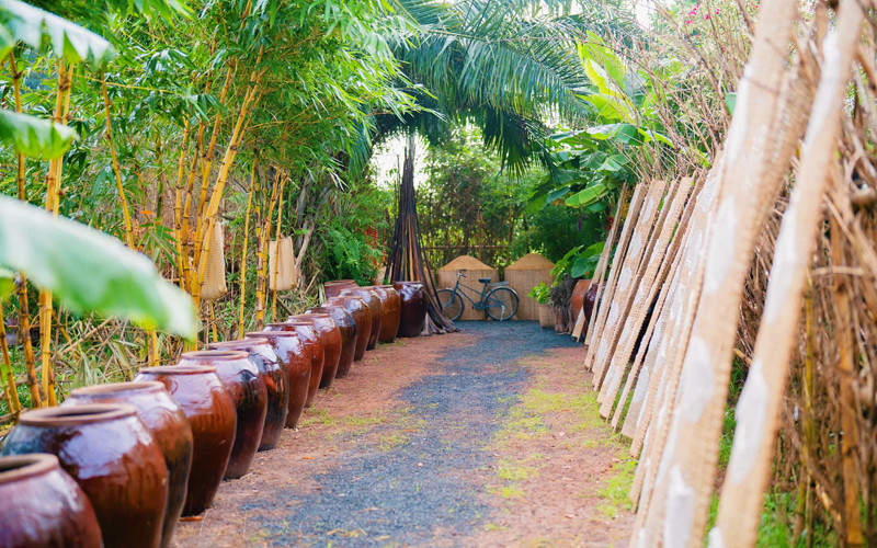 50 chiếc lu chứa nước mưa được xếp ngay ngắn ở lối đi và được dùng làm bình cắm hoa thiên điểu, cỏ mỹ 50 chiếc lu chứa nước mưa được xếp ngay ngắn ở lối đi và được dùng làm bình cắm hoa thiên điểu, cỏ mỹ