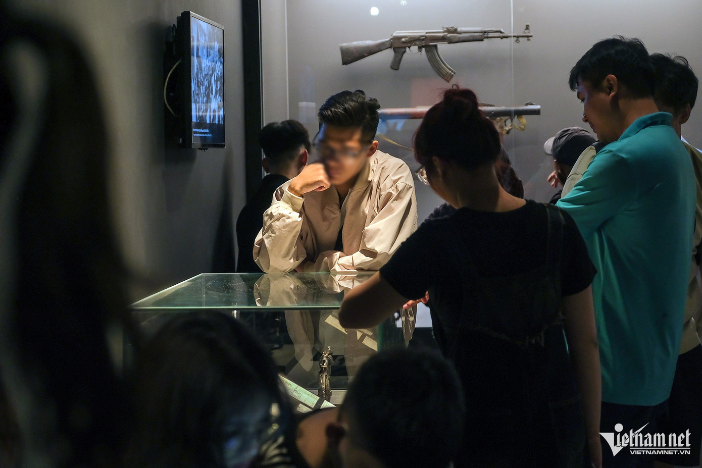 Trong đó có cả đè cánh tay, tỳ khuỷu tay lên tủ kính, bên trong là những hiện vật quý giá và mang nhiều ý nghĩa.