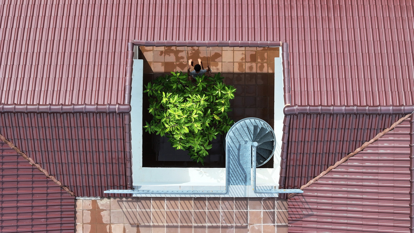 Hành lang được thiết kế với các cấp độ so le theo địa hình dốc thoai thoải của khu đất, kết nối với một sân nhỏ, dẫn đến phòng khách, bếp và phòng ngủ. Thiết kế này làm phong phú thêm trải nghiệm sống hàng ngày, tạo ra những khoảnh khắc thú vị nhất trong những ngày mưa hay nắng.